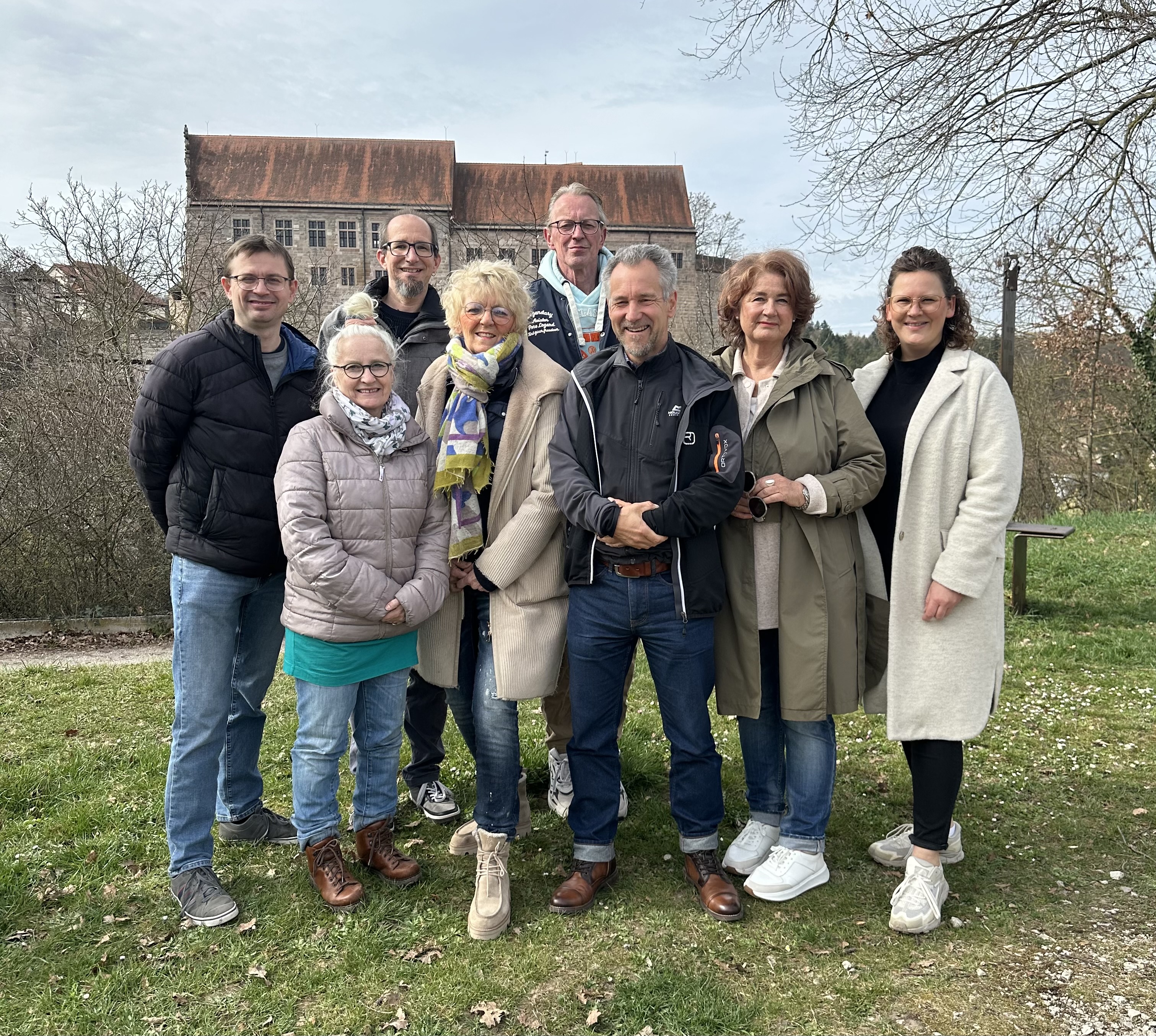 Eine Gruppe von Menschen steht auf dem Höhbuck in Cadolzburg. Im Hintergrund ist die Burg zu sehen. Die Menschen blicken freundlich und zugewandt in die Kamera.